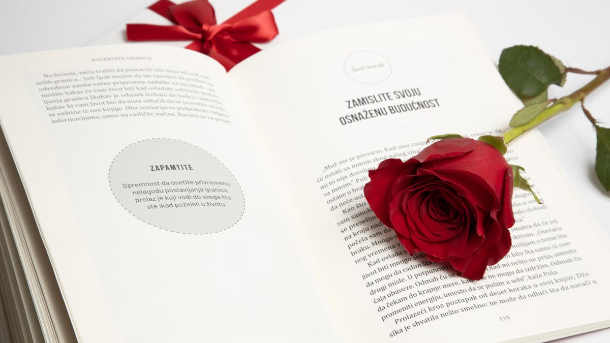Elegant red rose on an open book with a red ribbon, symbolizing romance and literature.